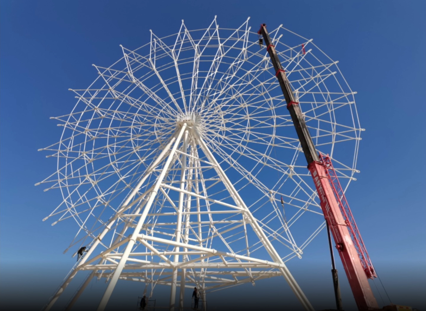 西华公园旁,湛蓝天空的下,阳光照射着纯白色,快要搭建好的摩天轮现
